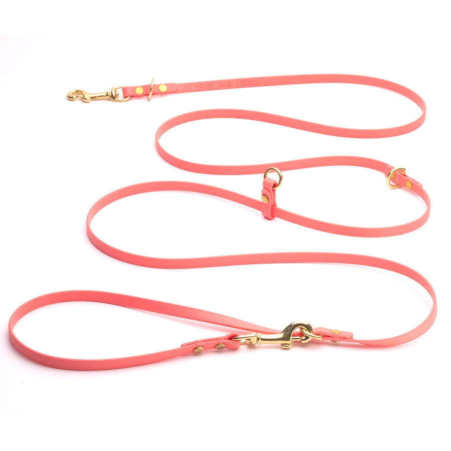 coral biothane hands free dog leash with brass hardware on white background